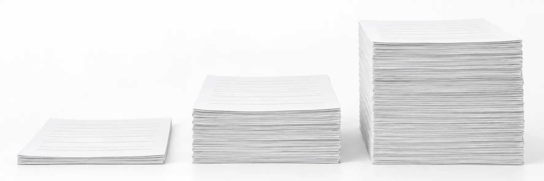 Three stacks of printed pages of different thicknesses standing side by side on a white surface